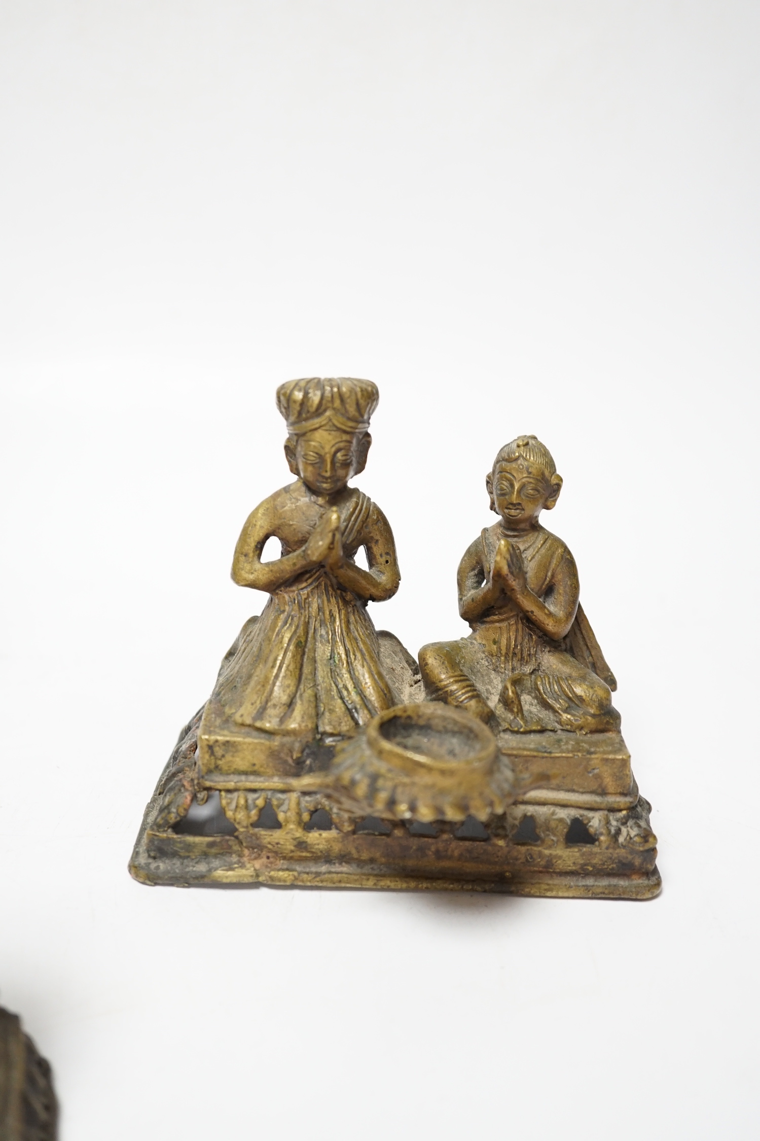 Three Nepalese figural brass oil lamps, 18th/19th century